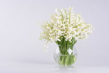 Lily of the valley in a glass vase isolated on white background