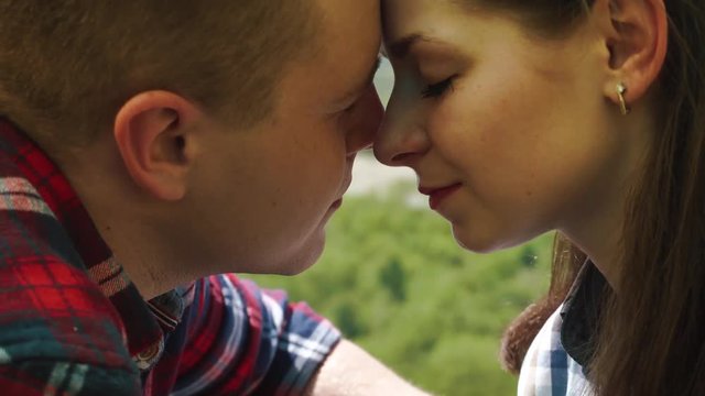 Young tourist couple have a sensual moment in tent. Beautiful young man and woman share rubbing their noses