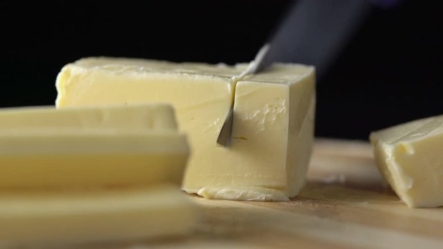 Sliced pieces of butter on wooden background