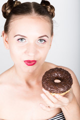 girl in bright makeup eating a tasty donut with icing. Funny joyful woman with sweets, dessert. dieting concept. junk food