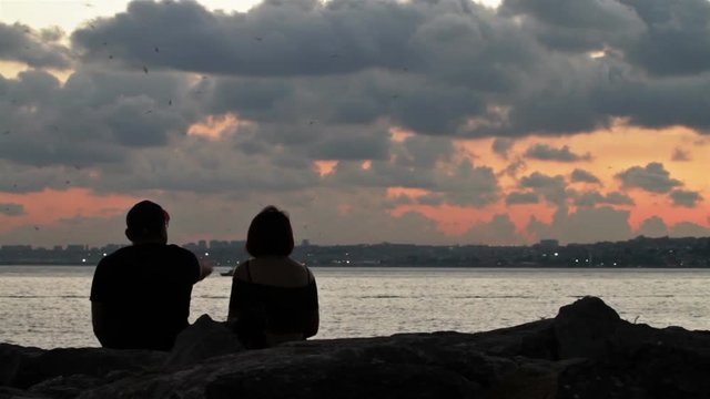 A silhouette of a couple chatting at the water front ,Istanbul