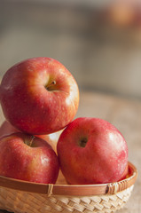 Fresh harvest of apples. Nature theme with red grapes and basket on wooden background. Nature fruit concept.