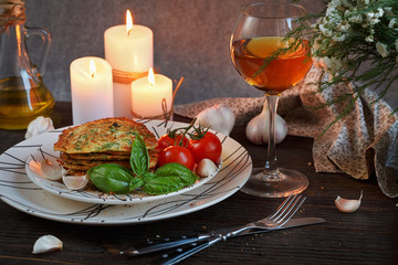 Vegetarian zucchini fritters served with fresh herbs, tomatoes a