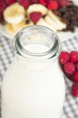 bottle of fresh milk and granola with fruits