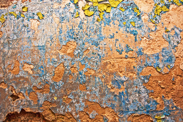 Grunge wall with cracks and peeling paint in old house. Textured background