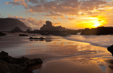 Sunset on the Ocean. Evening low tide on the sandy coast. Seascape