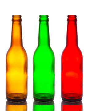 Empty bottles, brown, green and red isolated white backdrop.