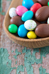 Easter candy eggs on old wooden surface