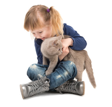 cute little girl sitting on the floor with cat in hands isolated on white background