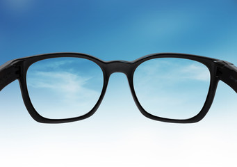 Glasses looking on blue sky, with out of focus and correct vision on lens