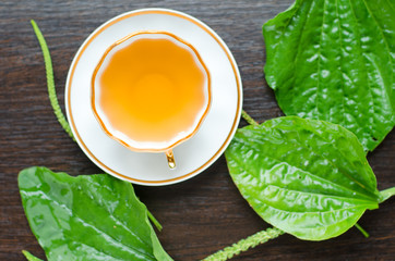 herbal plantain tea in a porcelain Cup on a dark wooden background