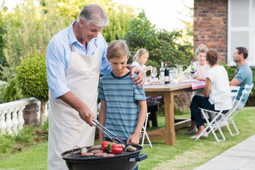Grandfather cooking with grandson