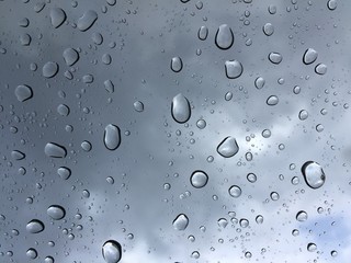 drops of rain on car glass with dark clouds - background