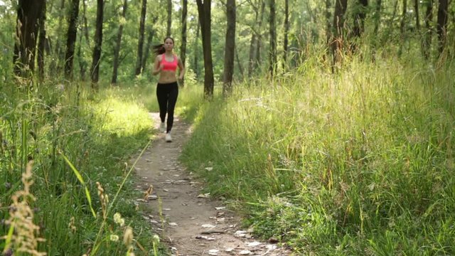 Athletic woman running on path in the park