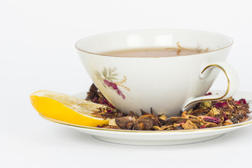 Cup of tea with loose rooibos tea leaves and slice of lemon