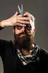 bearded man with hairdresser scissors