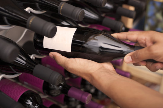 Wine taster showing wine bottles with copyspace