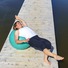 Pilates-Training auf einem sonnigen Steg am See