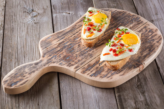 scrambled eggs with bread on cutting board