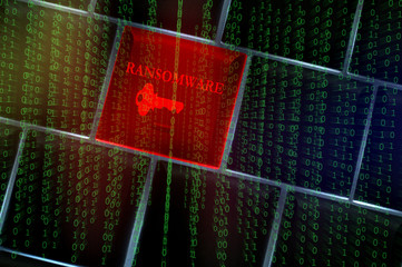 Ransomware concept with backlit laptop keyboard overlaid with binary codes
