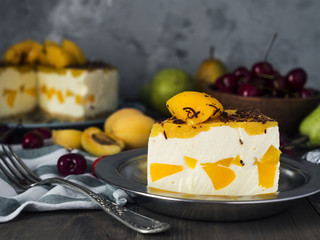 cream peach mousse cake with  fruits on wooden table 
