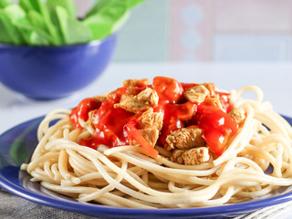 pasta with chicken and tomato sauce on a blue plate