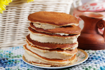Pancake cake with cream on a plate Still