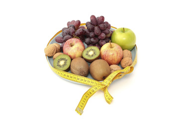 Fresh fruit on a plate with a measure tape