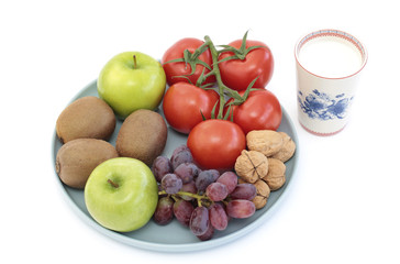 Variety of fruit, walnuts, tomatoes and a glass of milk