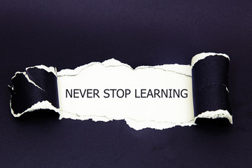 NEVER STOP LEARNING message written under torn paper. 
