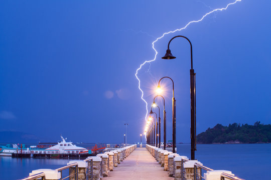 Lightning bolt strike into sea with natural lens flare - Powered by Adobe