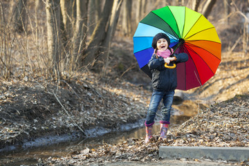 Girl with multicolored umbrella in autumn park
