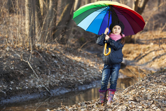 Girl with multicolored umbrella in autumn park