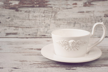 Fototapeta na wymiar Simple rustic white crockery, empty dishes. A large cup of coffee in front angel. Wooden background, shabby chic, vintage tinting, copy space