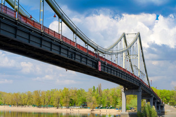 Pedestrian bridge over a cloudy sky Dnieper River in Kiev