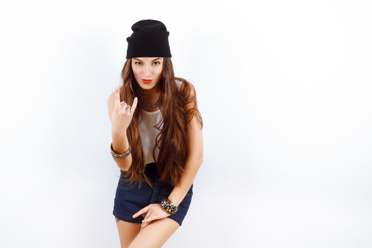 Cool young girl in black hat showing sign of the horns