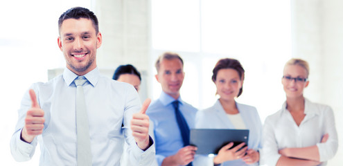 businessman in office showign thumbs up