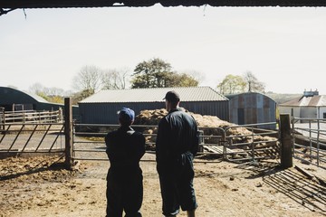 Farm workers on field against clear sky