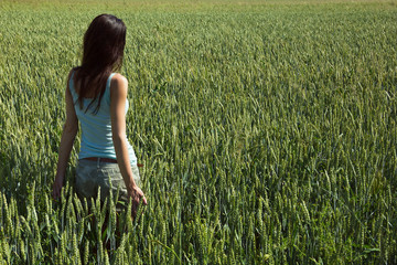 girl in the unripe green wheat field