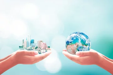 Photo sur Plexiglas construction de la ville Concept de la Journée mondiale de l& 39 environnement : deux mains humaines tenant une grande ville et un globe terrestre sur fond de nature bleue. Éléments de cette image fournis par la NASA