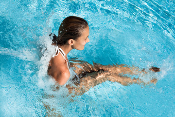 femme avec des jets d'eau dans une piscine - obrazy, fototapety, plakaty