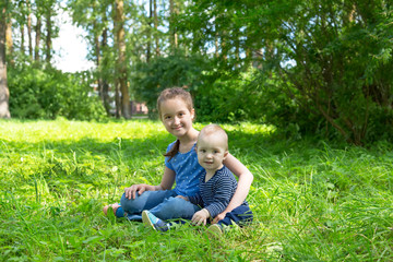 Naklejka na ściany i meble adorable baby boy and girl playing in summer park