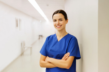 happy doctor or nurse at hospital corridor - obrazy, fototapety, plakaty