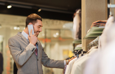 happy man calling on smartphone at clothing store