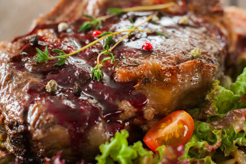 Fried pork steak with red topping, lettuce and tomato close-up
