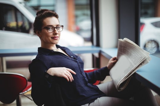 Portrait of woman holding newspaper