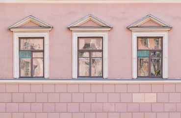 Three windows in a row on facade of urban apartment building front view, St. Petersburg, Russia.