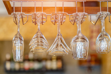 Empty glasses for wine above a bar rack