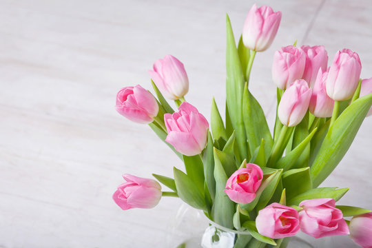 Pink tulips on a white wooden floor