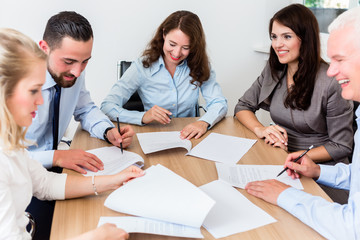 Rechtsanwälte lesen Dokumente bei Team Meeting in Kanzlei 